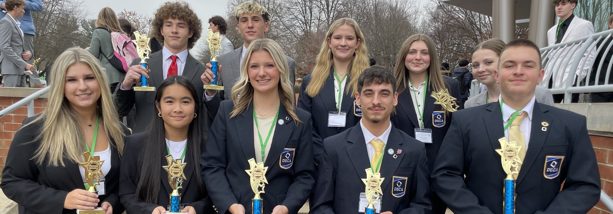 Picture of 10 DECA students with their trophies